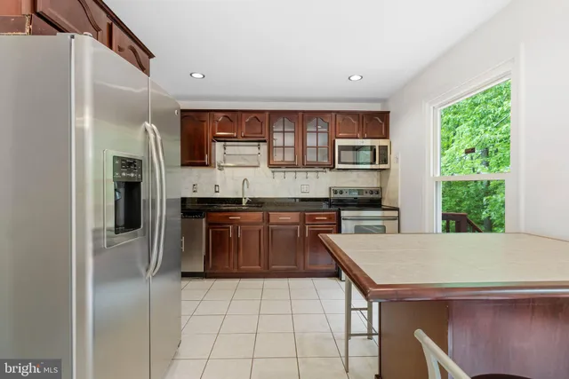 a kitchen with stainless steel appliances granite countertop a refrigerator and a stove