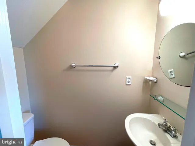 a bathroom with a sink mirror and toilet