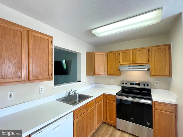 a kitchen with stainless steel appliances a stove sink and cabinets