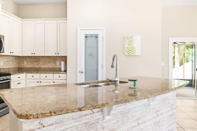 a kitchen with granite countertop a sink and a stove
