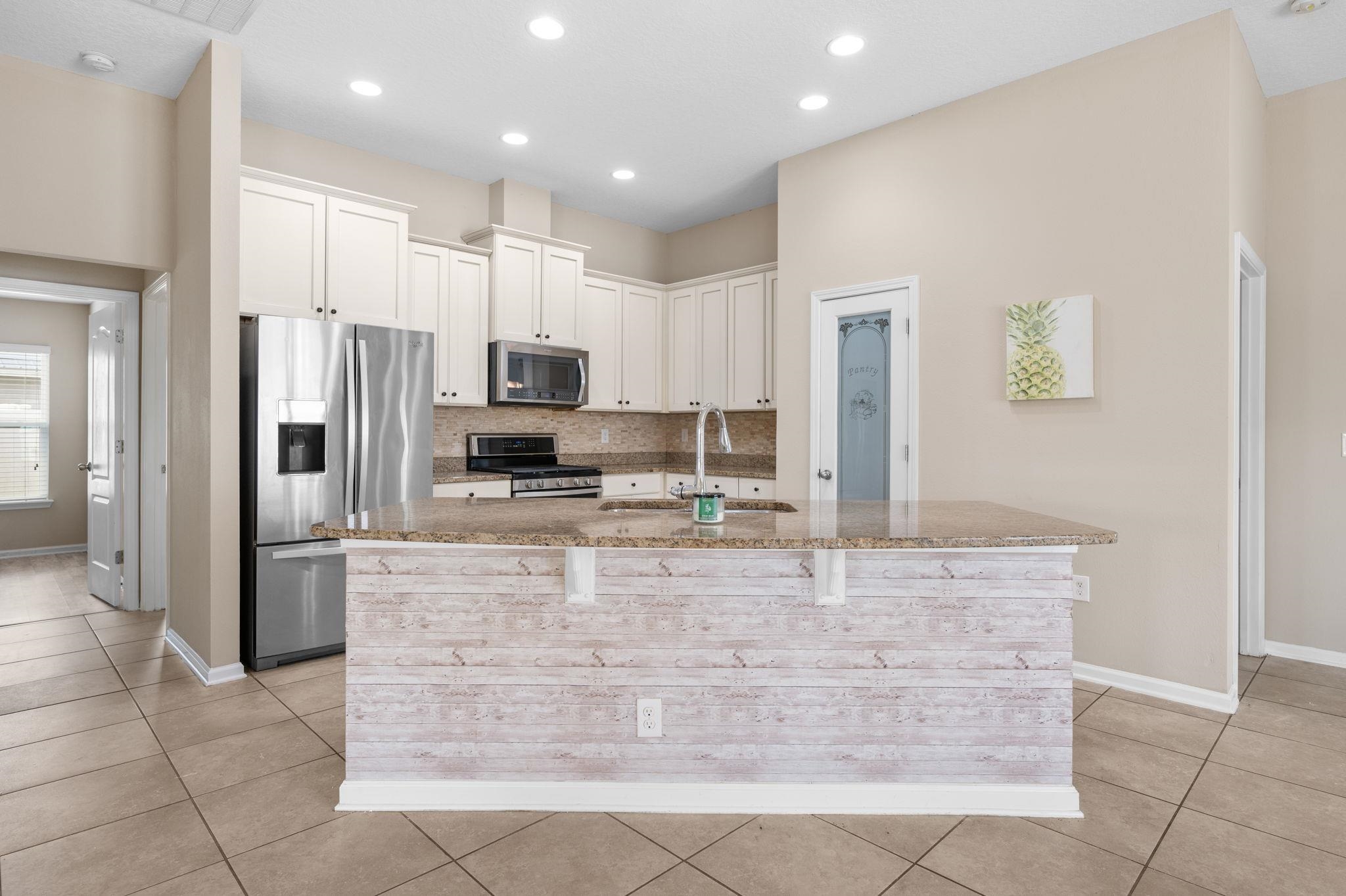 509 Deer Crossing Road St. Augustine, FL 32086 - Photo 14 of 54 a large kitchen with kitchen island granite countertop a large counter top stainless steel appliances and cabinets