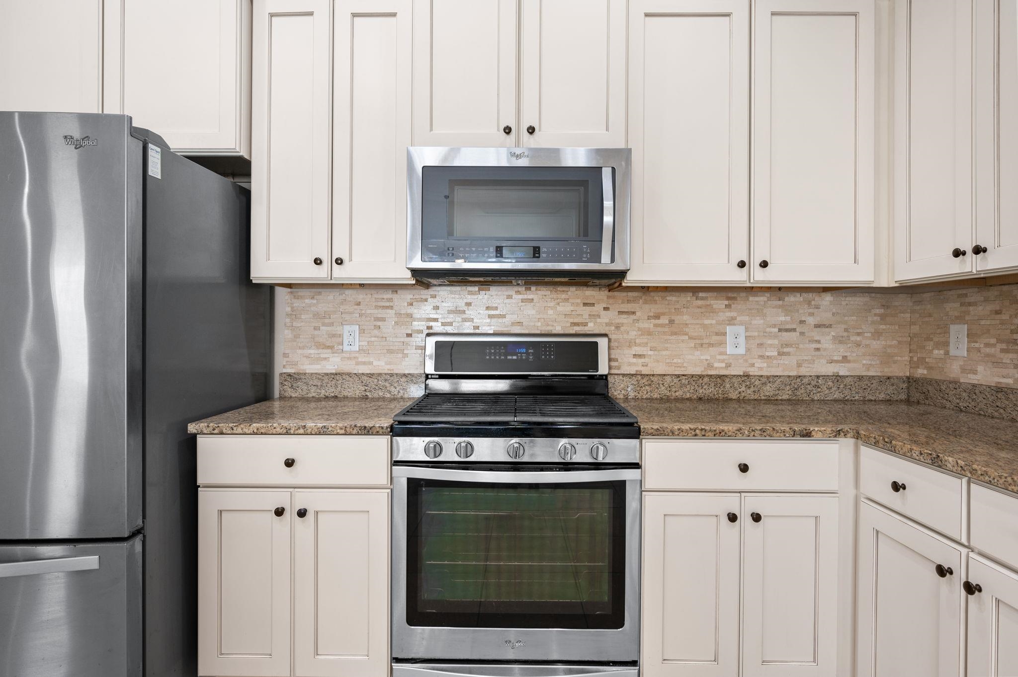 509 Deer Crossing Road St. Augustine, FL 32086 - Photo 15 of 54 a kitchen with granite countertop white cabinets and stainless steel appliances