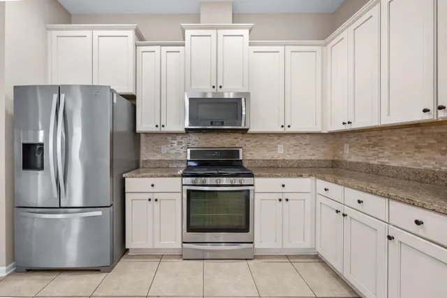 a kitchen with cabinets stainless steel appliances and a counter space