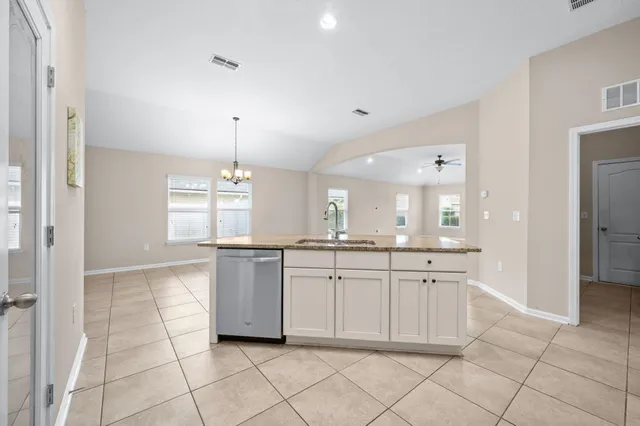 a large kitchen with granite countertop white cabinets and white appliances