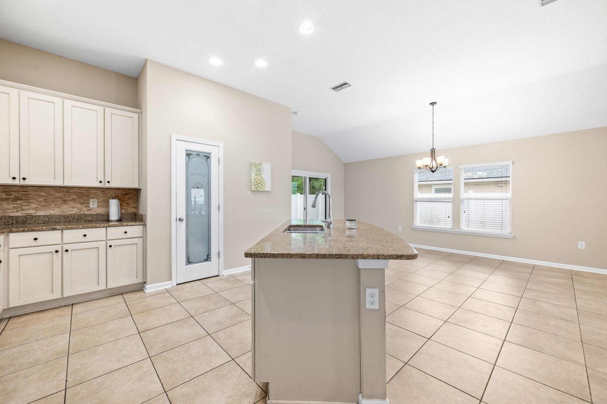 509 Deer Crossing Road St. Augustine, FL 32086 - Photo 18 of 54 a kitchen with kitchen island granite countertop a sink and a stove top oven