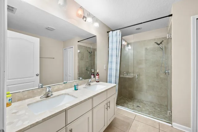 a bathroom with a shower sink vanity granite and mirror