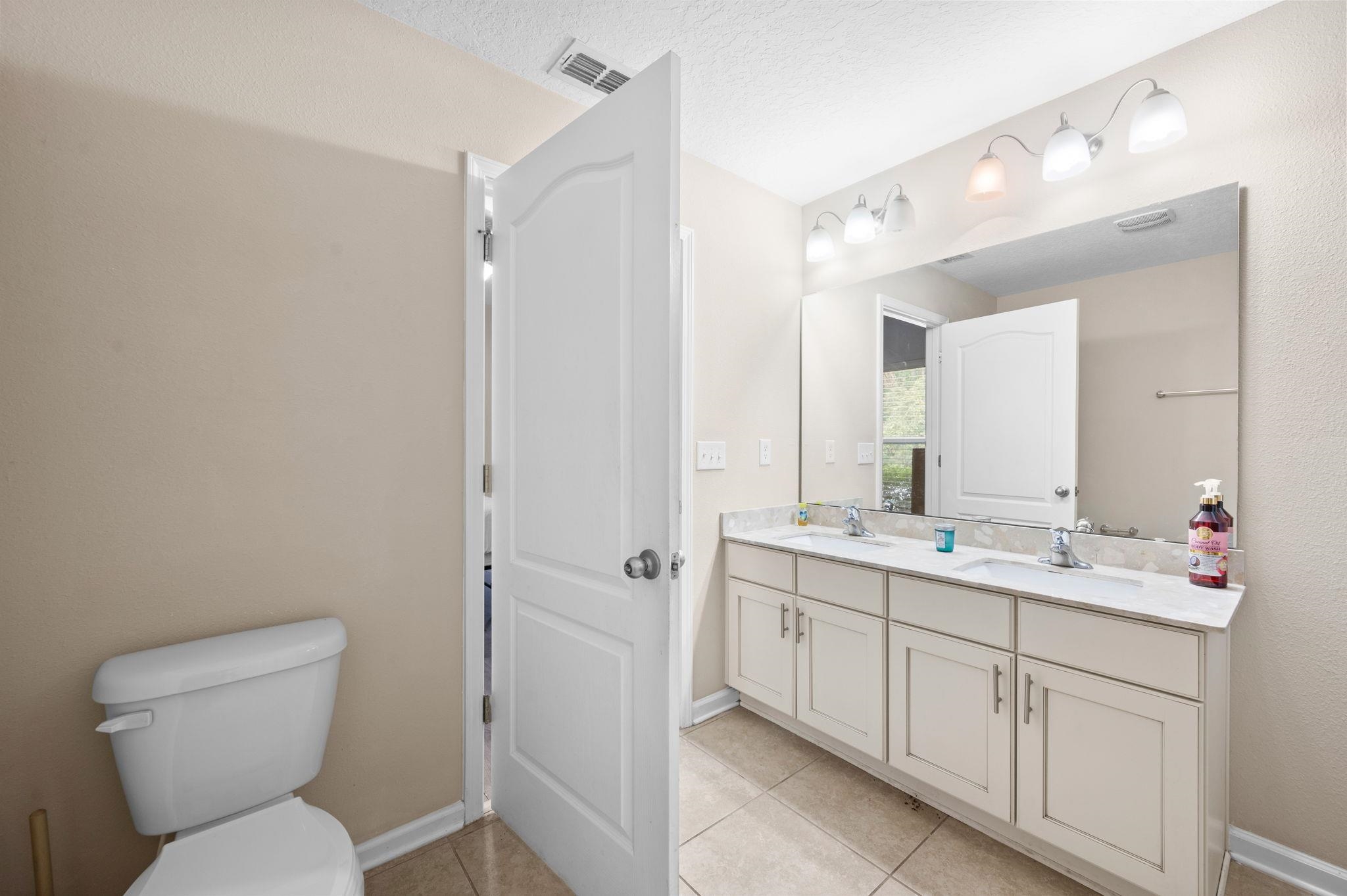 509 Deer Crossing Road St. Augustine, FL 32086 - Photo 24 of 54 a bathroom with a toilet sink and mirror