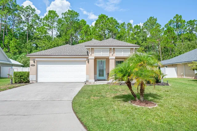a front view of a house with a yard and trees