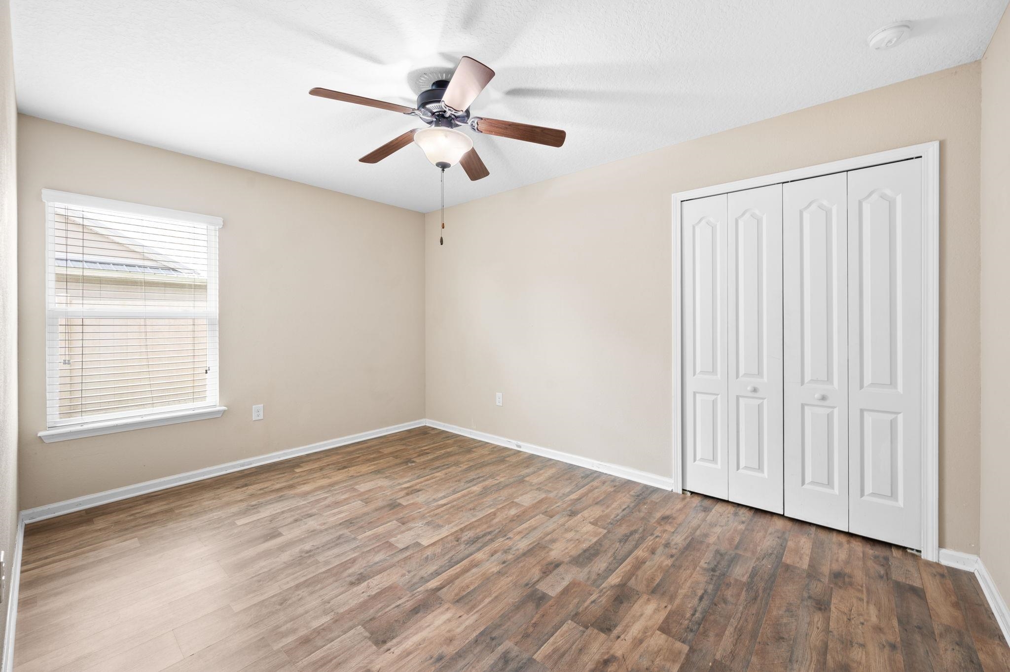 509 Deer Crossing Road St. Augustine, FL 32086 - Photo 31 of 54 an empty room with wooden floor fan and windows