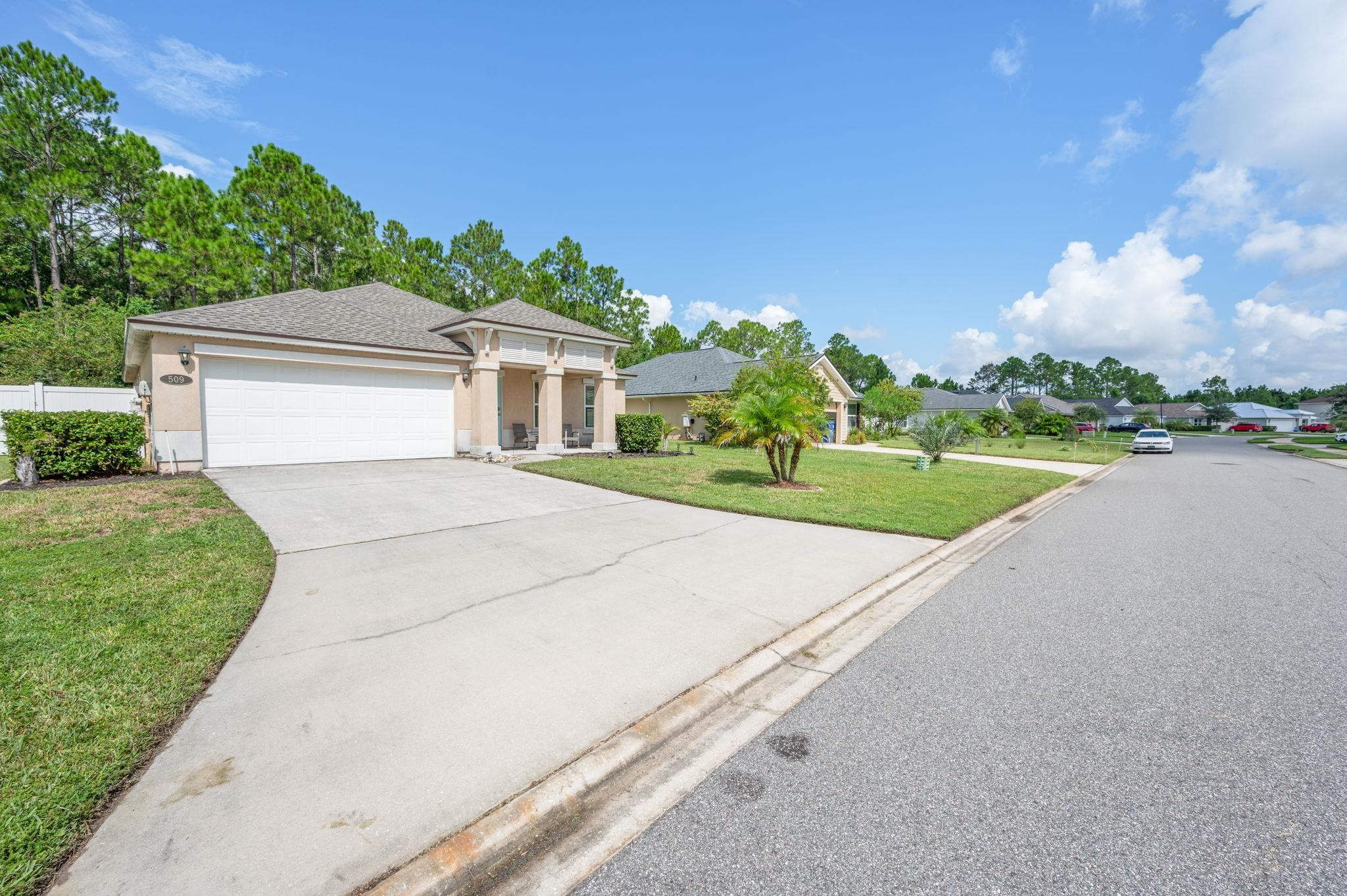 509 Deer Crossing Road St. Augustine, FL 32086 - Photo 4 of 54 a front view of a house with a yard and trees