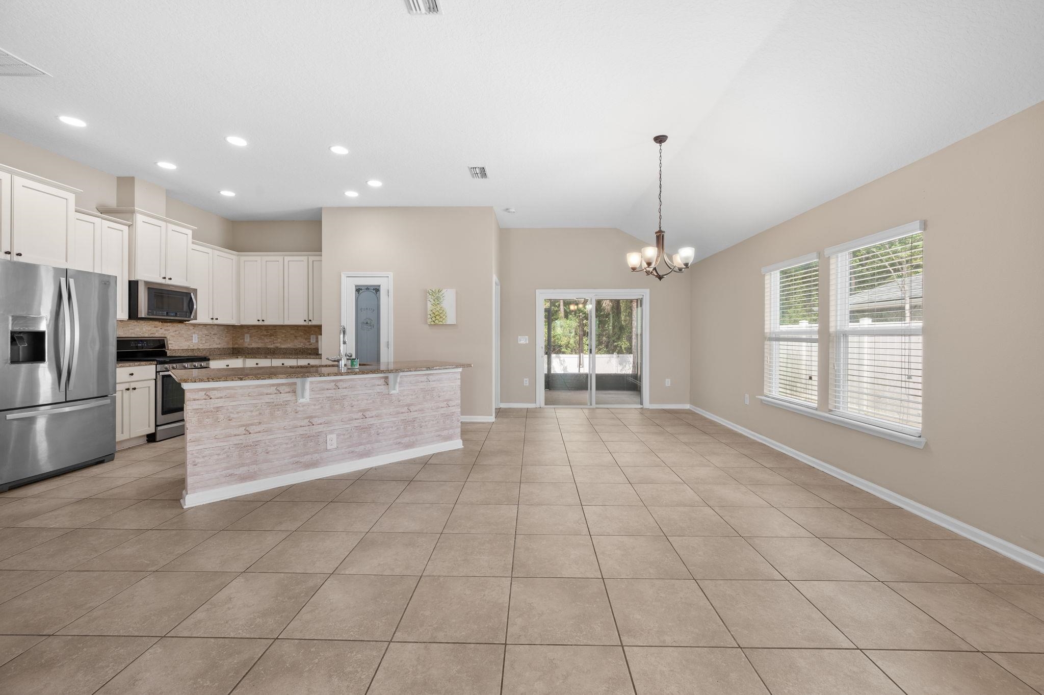 509 Deer Crossing Road St. Augustine, FL 32086 - Photo 10 of 54 a large kitchen with granite countertop a stove a sink and a refrigerator