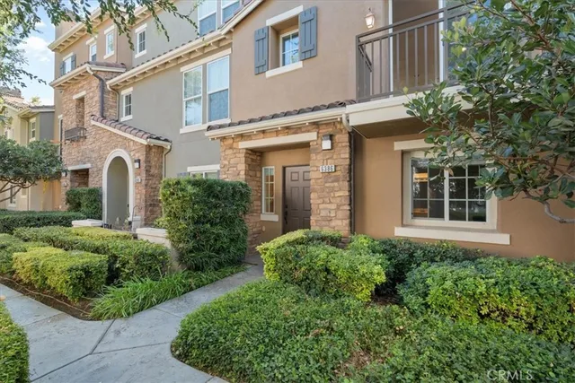 a view of a house with brick walls and plants