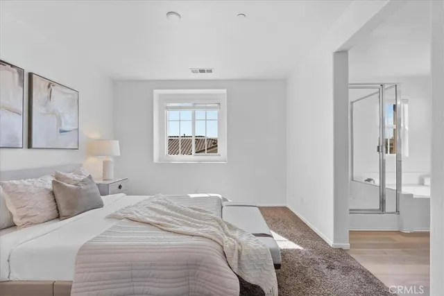 a bedroom with a bed and a painting on the wall