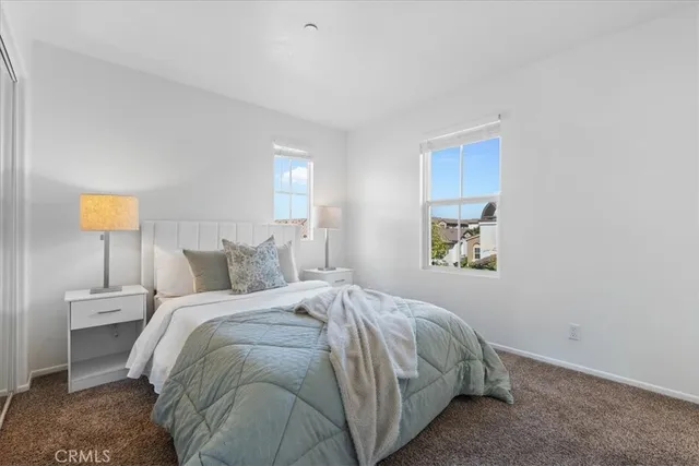 a bed sitting in a bedroom next to a lamp
