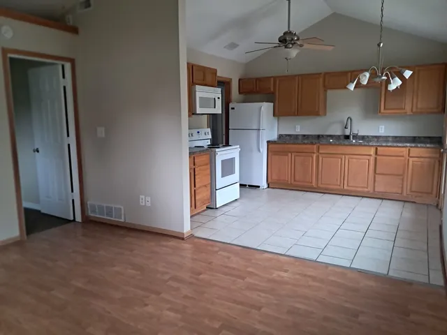 a large kitchen with stainless steel appliances granite countertop a stove a sink and a refrigerator