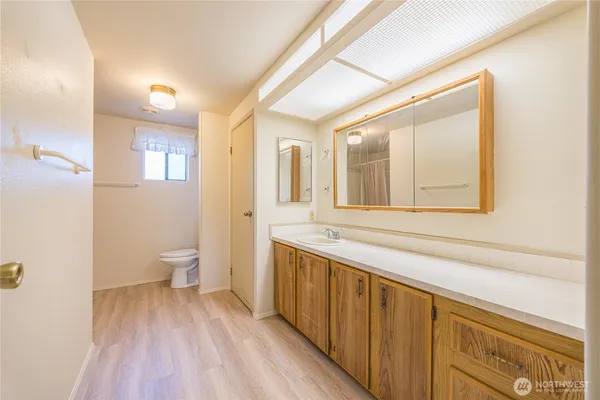 a bathroom with a sink mirror and a toilet