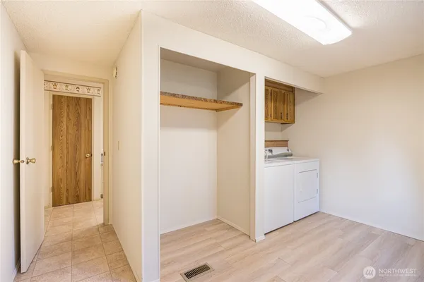 a view of a hallway with bathroom and wooden floor