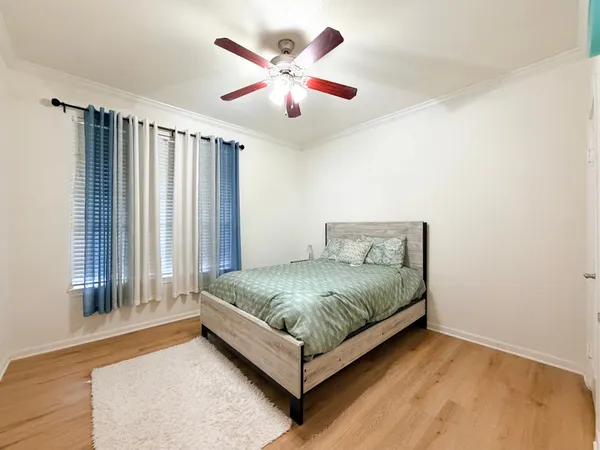 a spacious bedroom with a bed and a chandelier