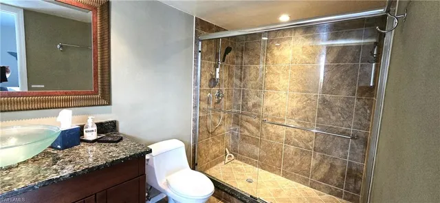 a bathroom with a granite countertop sink toilet and shower