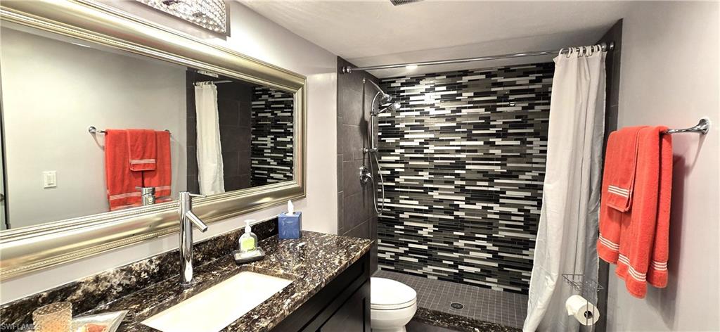 69 Georgetown Boulevard, Unit 69 Naples, FL 34112 - Photo 16 of 21 a bathroom with a granite countertop toilet sink and shower