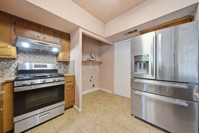 a kitchen with stainless steel appliances granite countertop a stove and a refrigerator