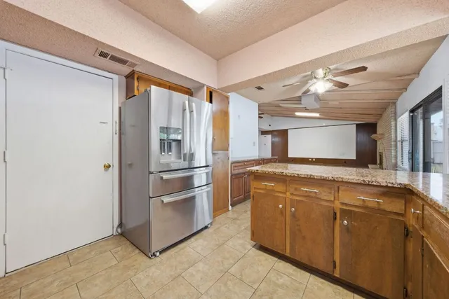 a kitchen with stainless steel appliances granite countertop a refrigerator and a sink