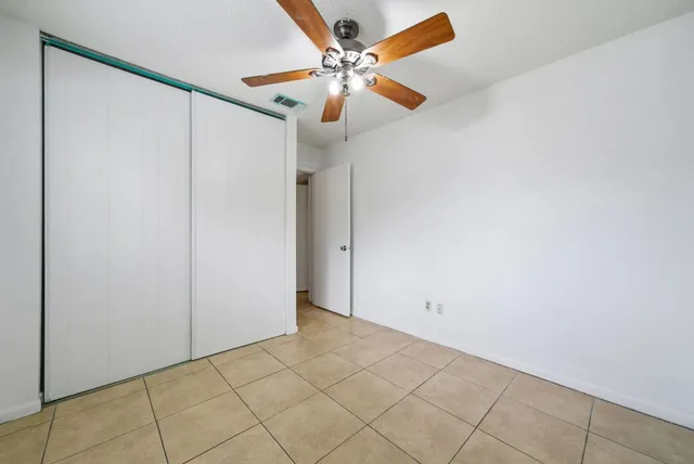 an empty room with a fan and a fan