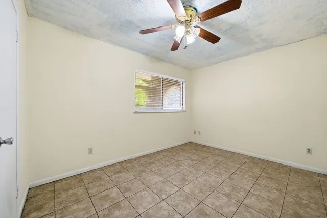 an empty room with a chandelier fan and fan