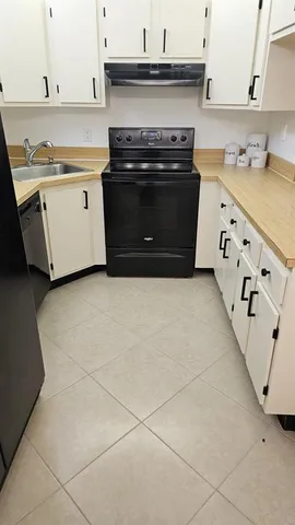 a kitchen with granite countertop a stove and a sink