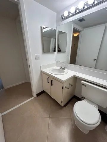 a bathroom with a sink a toilet and mirror