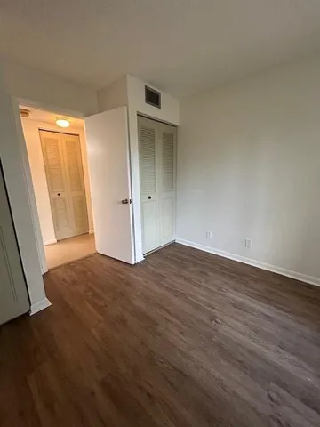 an empty room with wooden floor and closet