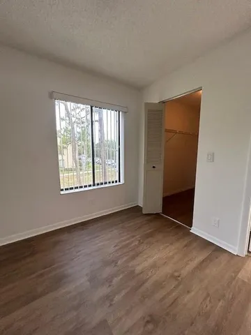 a view of a room with wooden floor and a bathroom