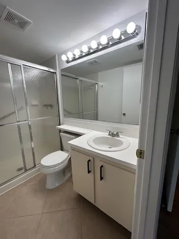 a white toilet sitting next to a shower