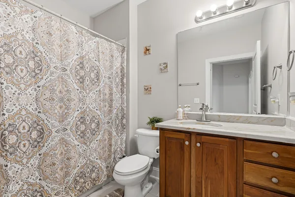 a bathroom with a granite countertop sink toilet and mirror