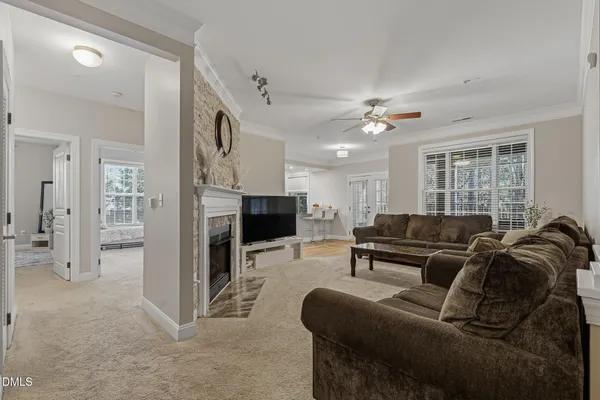 a living room with furniture a fireplace and a ceiling fan