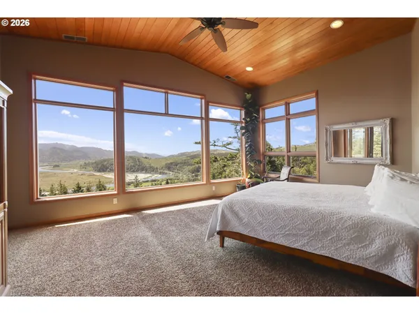 a view of a room with a large window and a bed