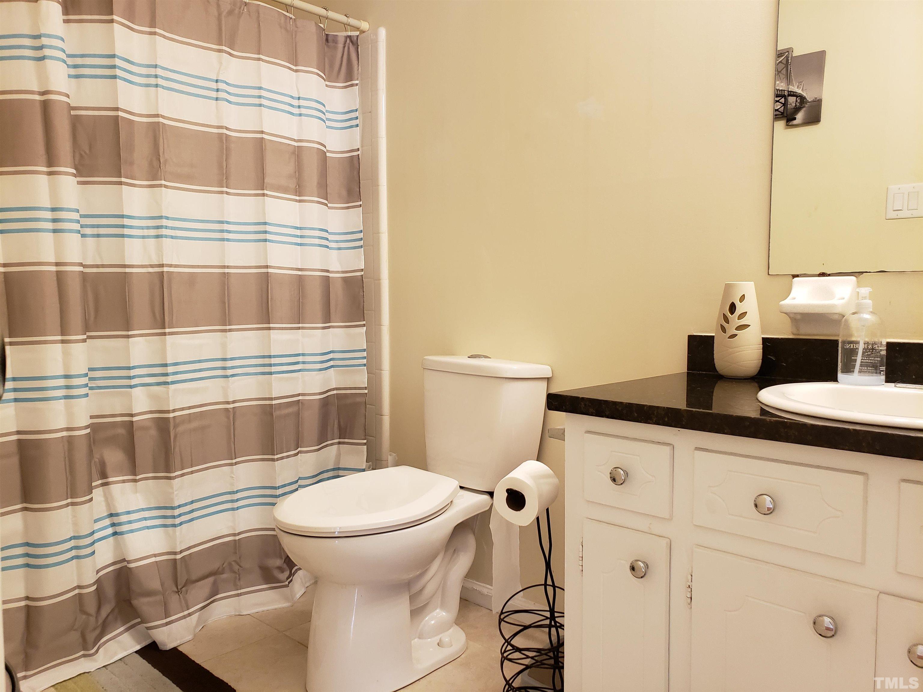 5610 Earl Road Durham, NC 27712 - Photo 14 of 38 a bathroom with a granite countertop sink toilet and shower
