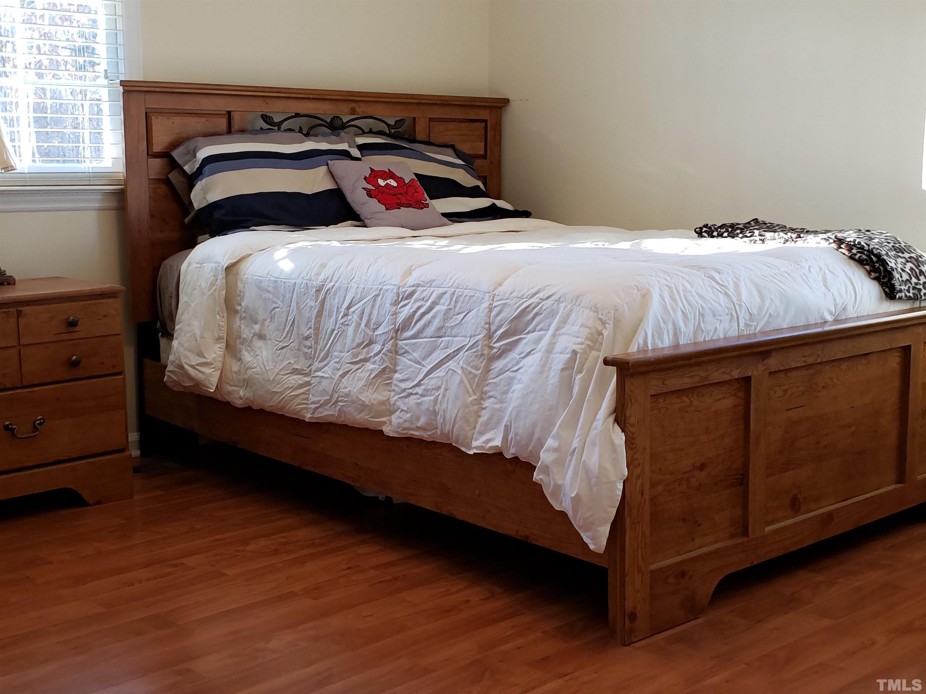 5610 Earl Road Durham, NC 27712 - Photo 19 of 38 a bedroom with a bed and a dresser with wooden floor