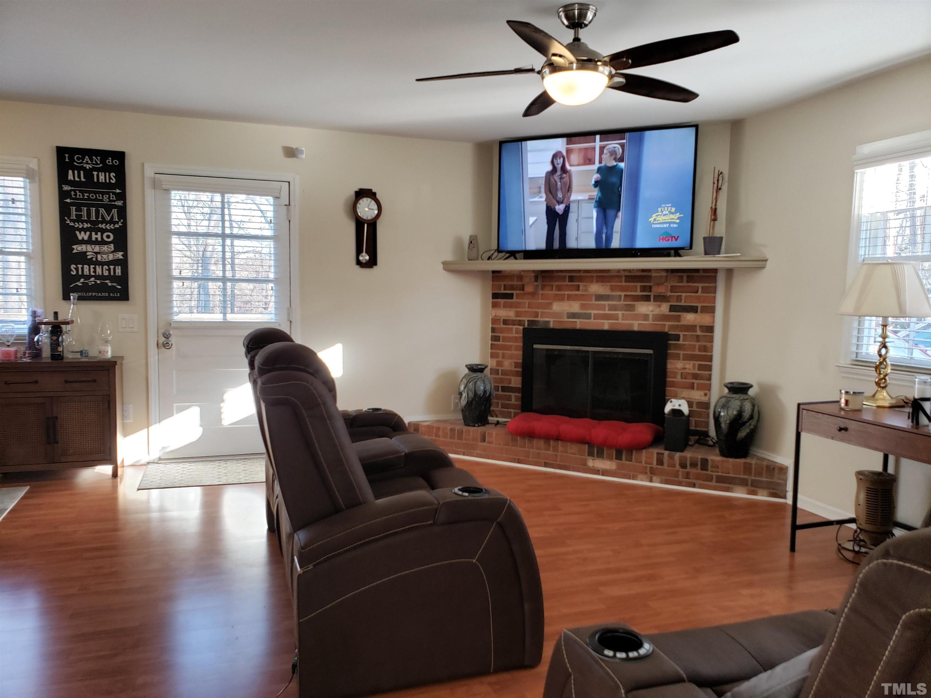5610 Earl Road Durham, NC 27712 - Photo 25 of 38 a living room with furniture a fireplace and wooden floor