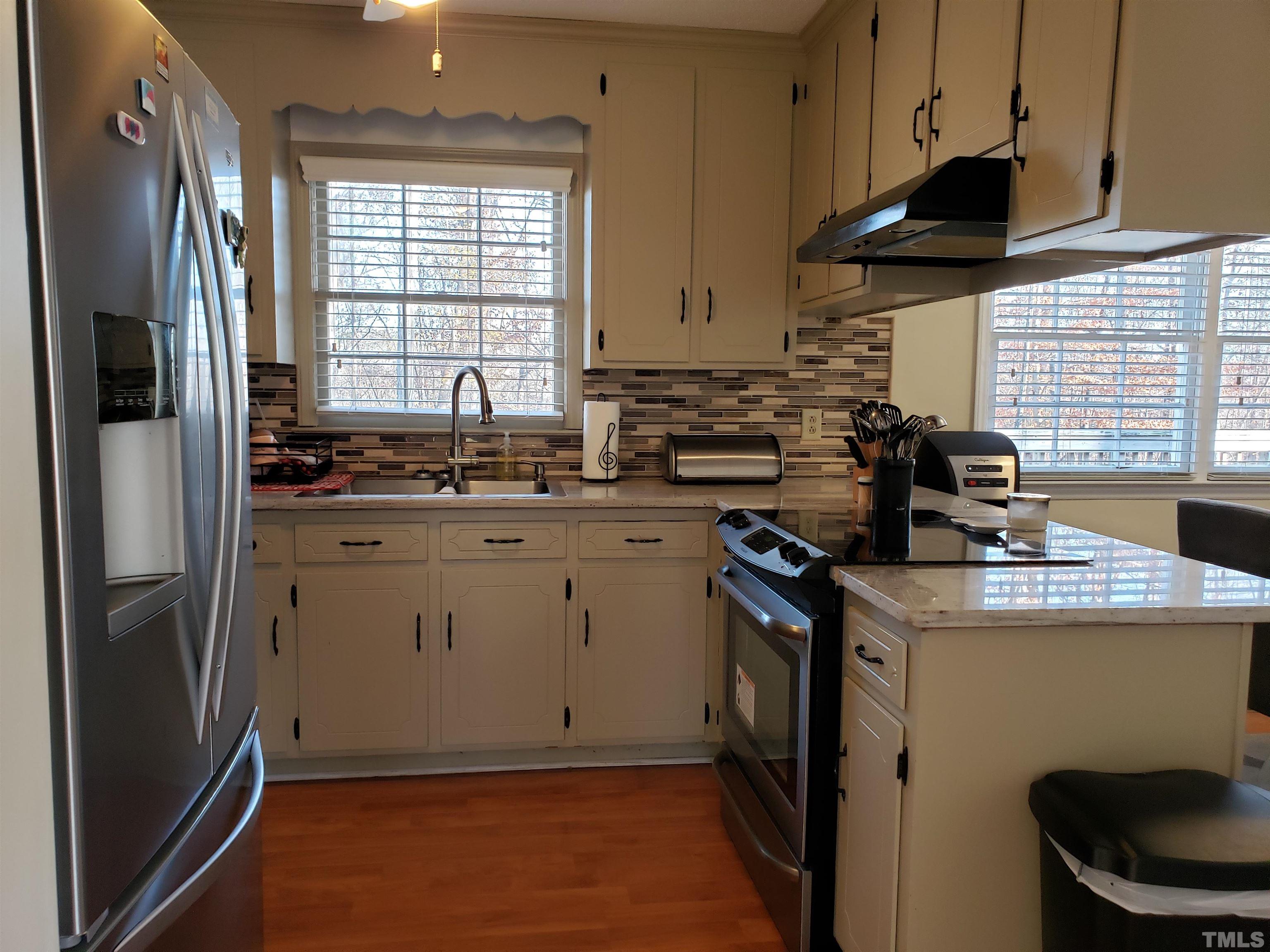 5610 Earl Road Durham, NC 27712 - Photo 36 of 38 a kitchen with a sink a stove a refrigerator and cabinets