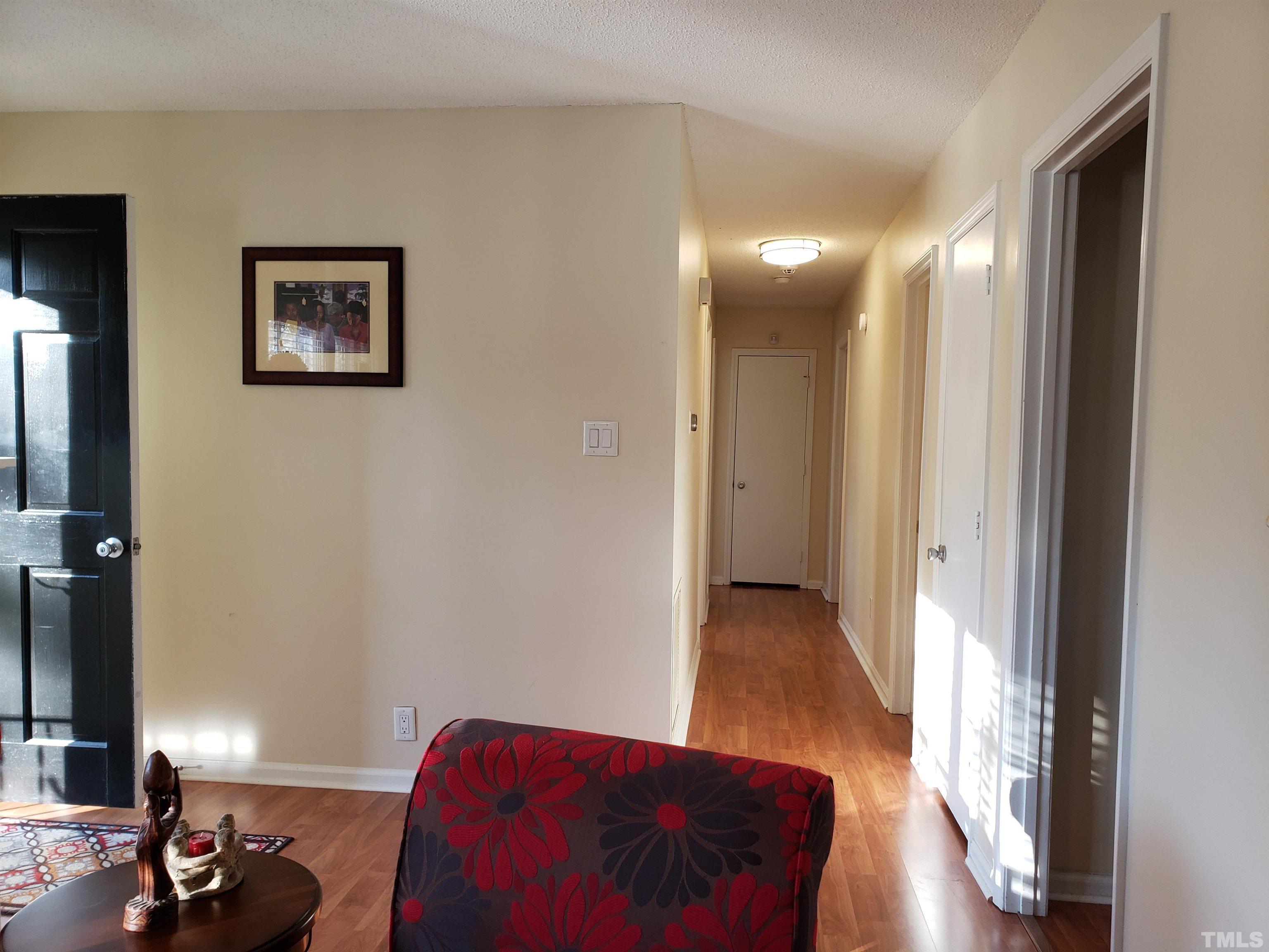 5610 Earl Road Durham, NC 27712 - Photo 8 of 38 a view of a hallway with wooden floor and a bathroom