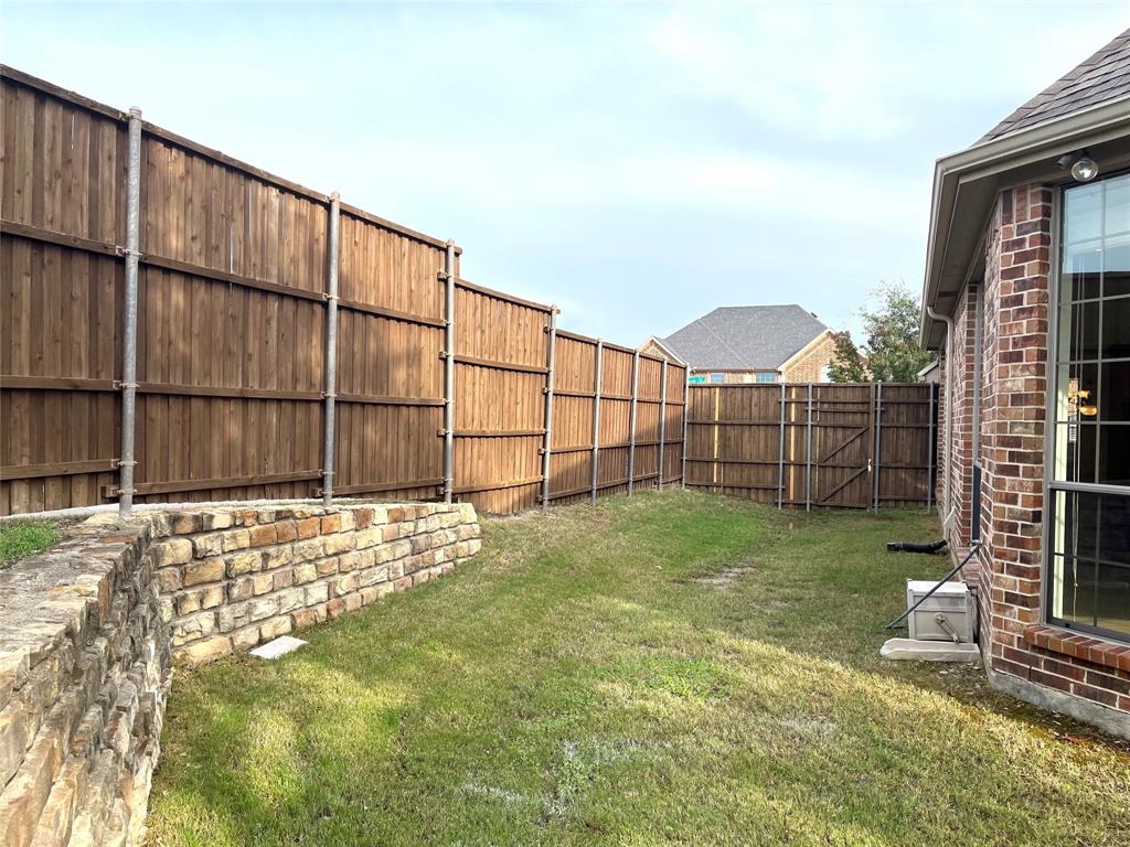4101 White Porch Road Plano, TX 75024 - Photo 17 of 18 Private backyard with wood panel fencing, brick retaining wall, and a side yard with mature landscaping