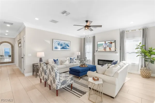 a living room with furniture a chandelier and a potted plant