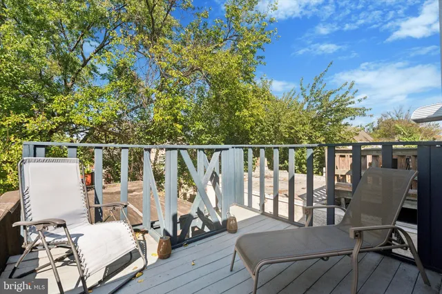 a balcony with wooden floor table and chairs