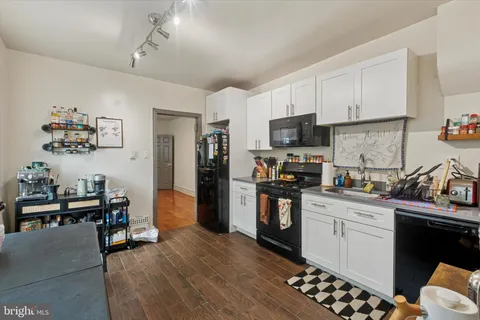 a kitchen with stainless steel appliances kitchen island granite countertop a refrigerator stove and sink