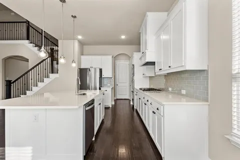 a kitchen with stainless steel appliances kitchen island granite countertop a sink and cabinets