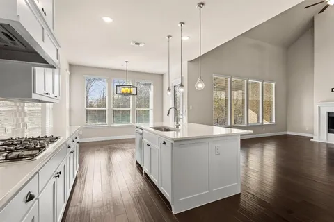 a open kitchen with stainless steel appliances granite countertop a stove and a wooden floors