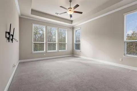 an empty room with windows and fan