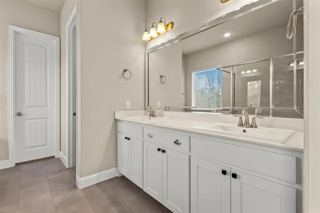 a bathroom with double sink and a mirror