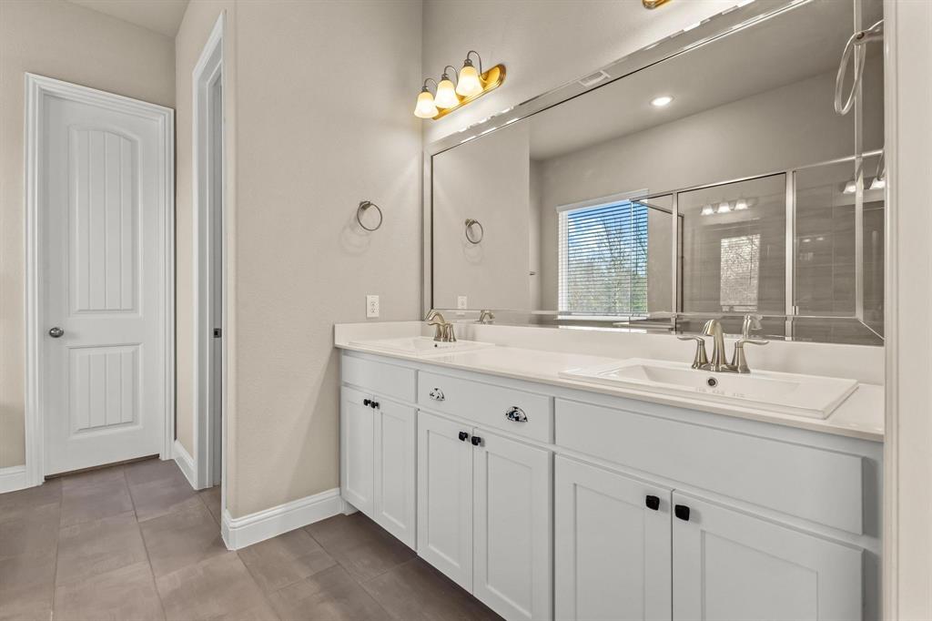 4001 Gentle Creek Lane Nevada, TX 75173 - Photo 21 of 40 a bathroom with double sink and a mirror